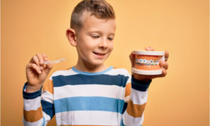 young boy holding braces