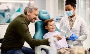 A father is smiling as his child received an excellent dental service.